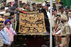 ‘Chaddar’ of flowers being given to BSF officers by the Pakistani Rangers for being laid on the Dargah of Baba Chamliyal.