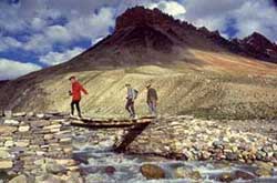 Trekkers crossing a foot bridge on Padum-Manali route